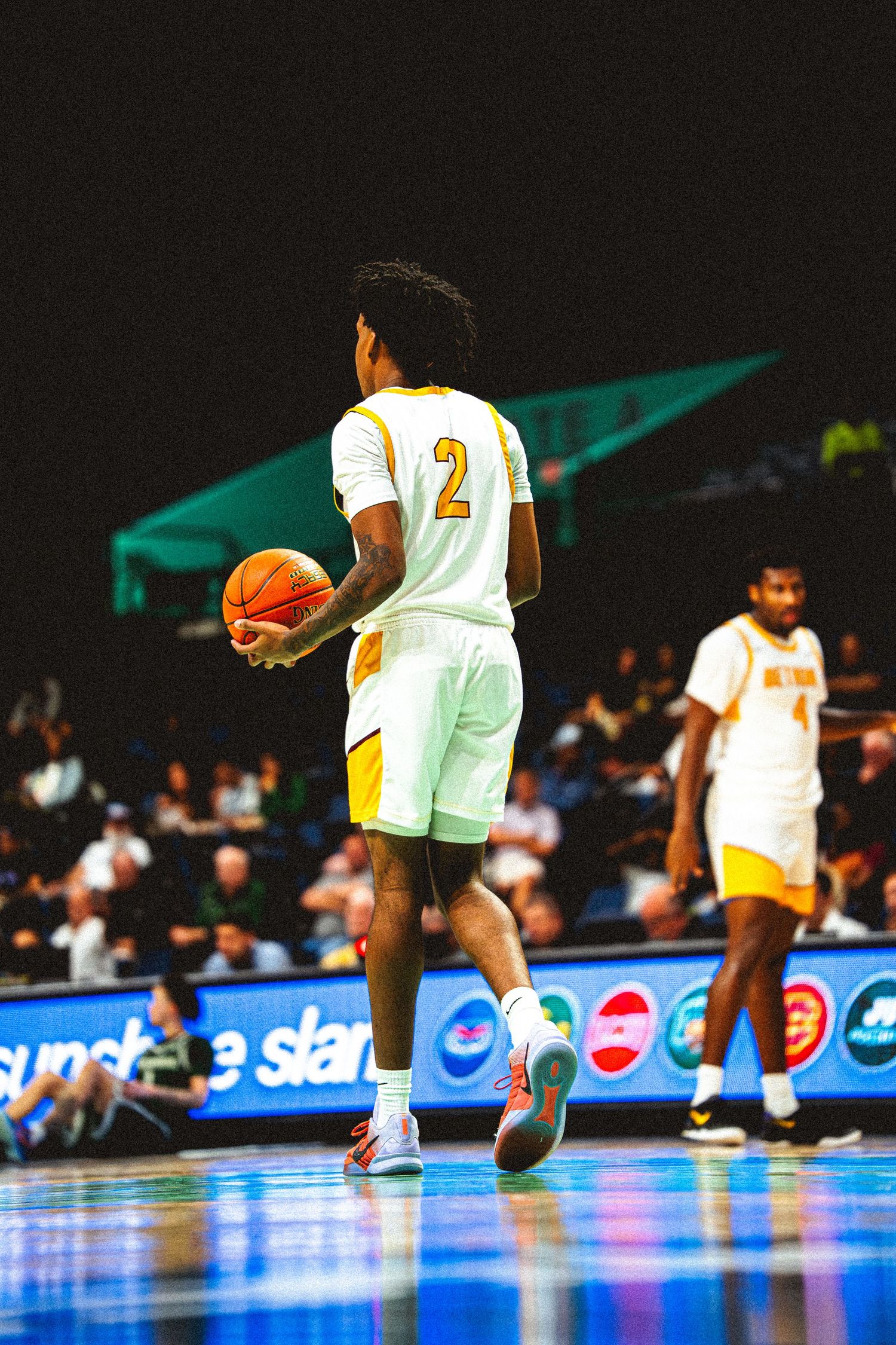 Bethune-Cookman basketball player number 2 dribbles ball on court during college game.