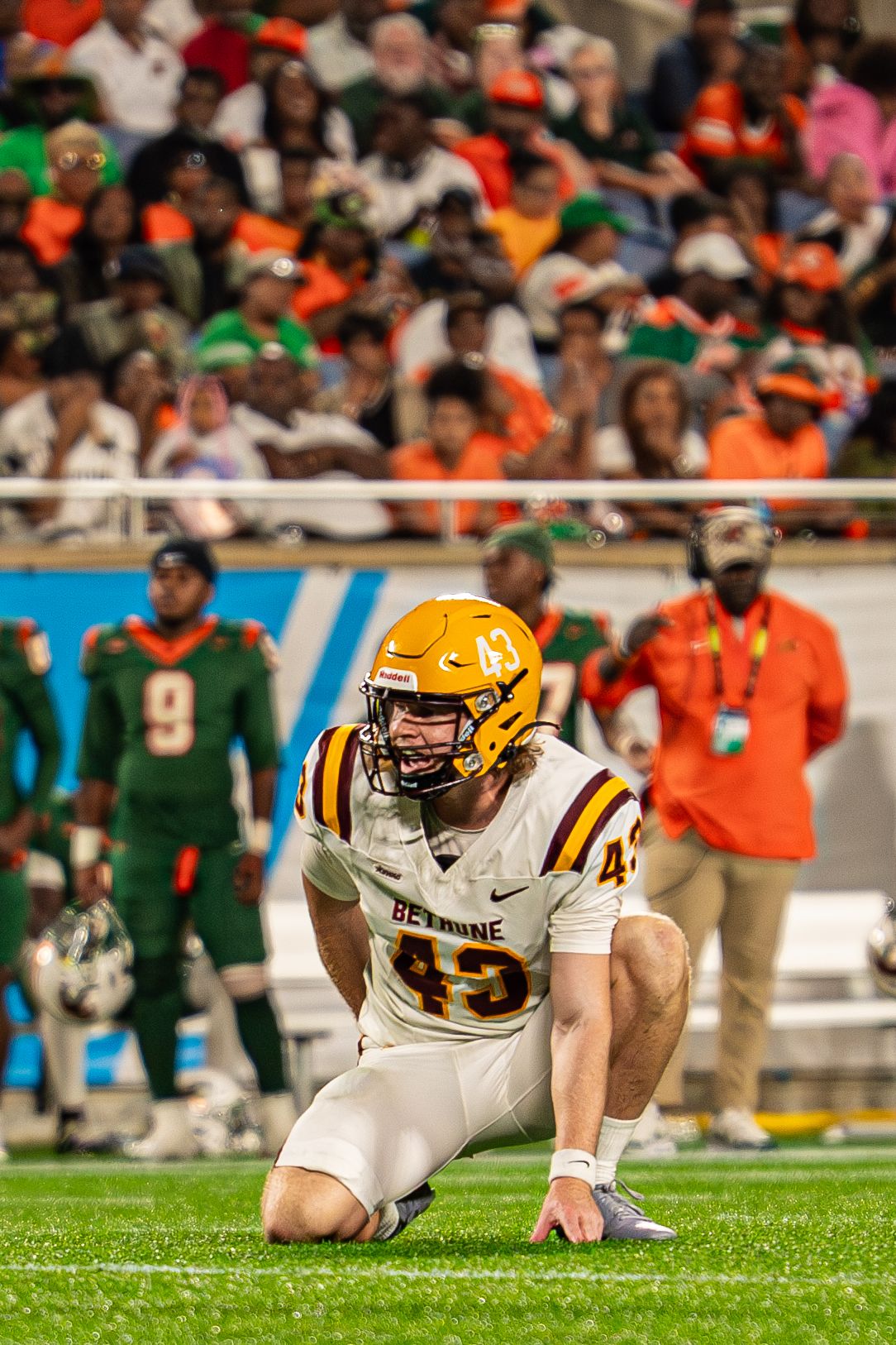 Bethune-Cookman football player #43 kneels on the field during a game against FAMU.
