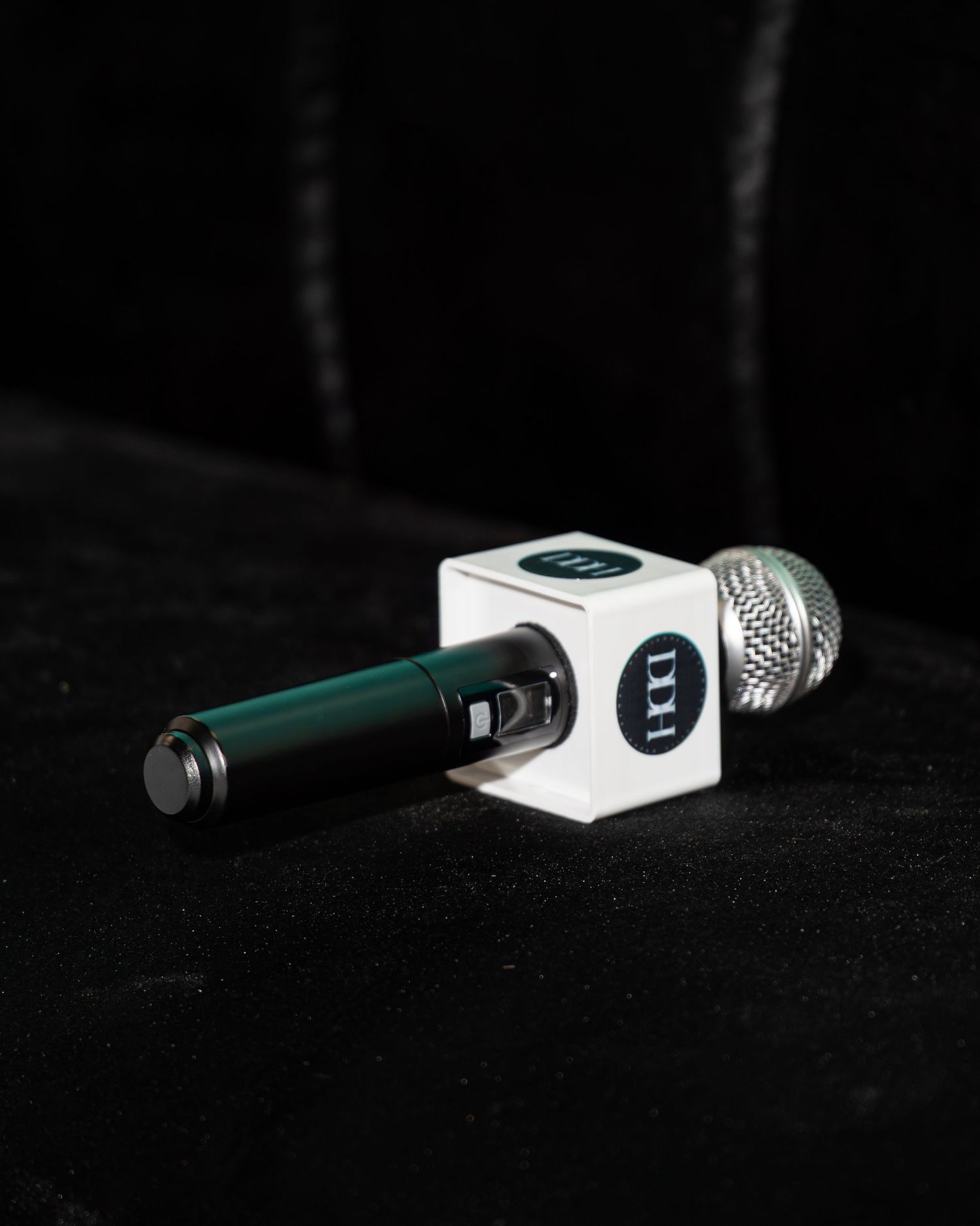 DDH branded microphone resting on black velvet surface at entrepreneur event.