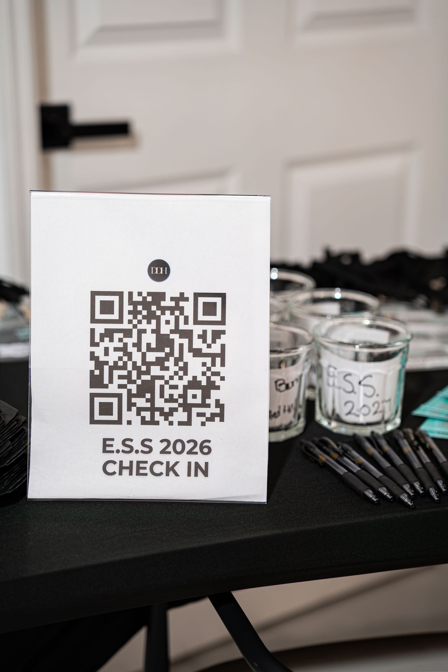 E.S.S 2026 check-in sign with QR code on a black table at an entrepreneur networking event.