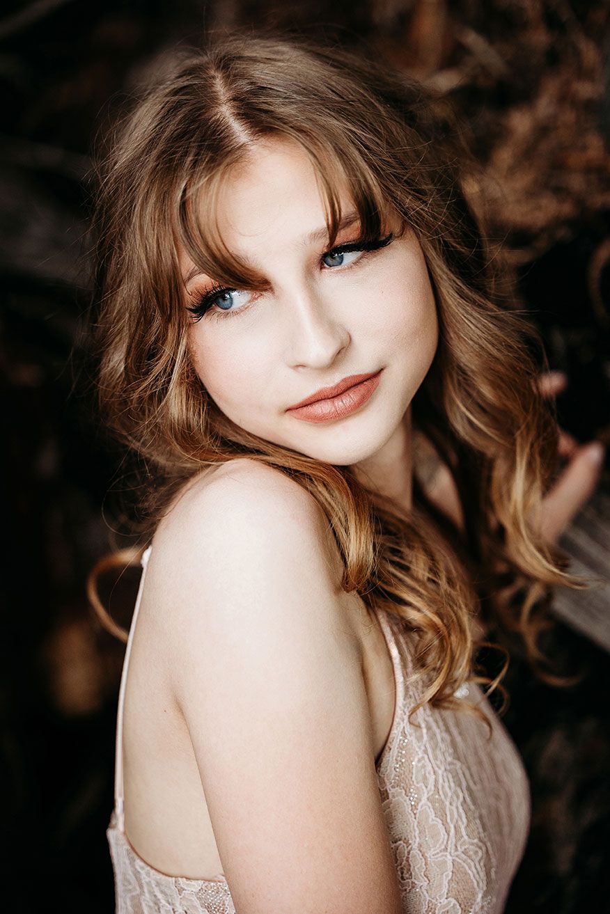 High School Senior Portrait of girl with long brown hair.  She is looking over her shoulder.