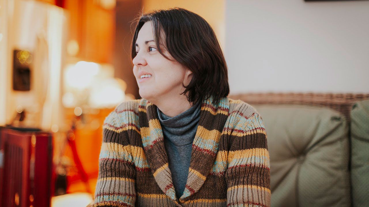 Stephanie Buechler wearing a snuggly sweater and smiling.