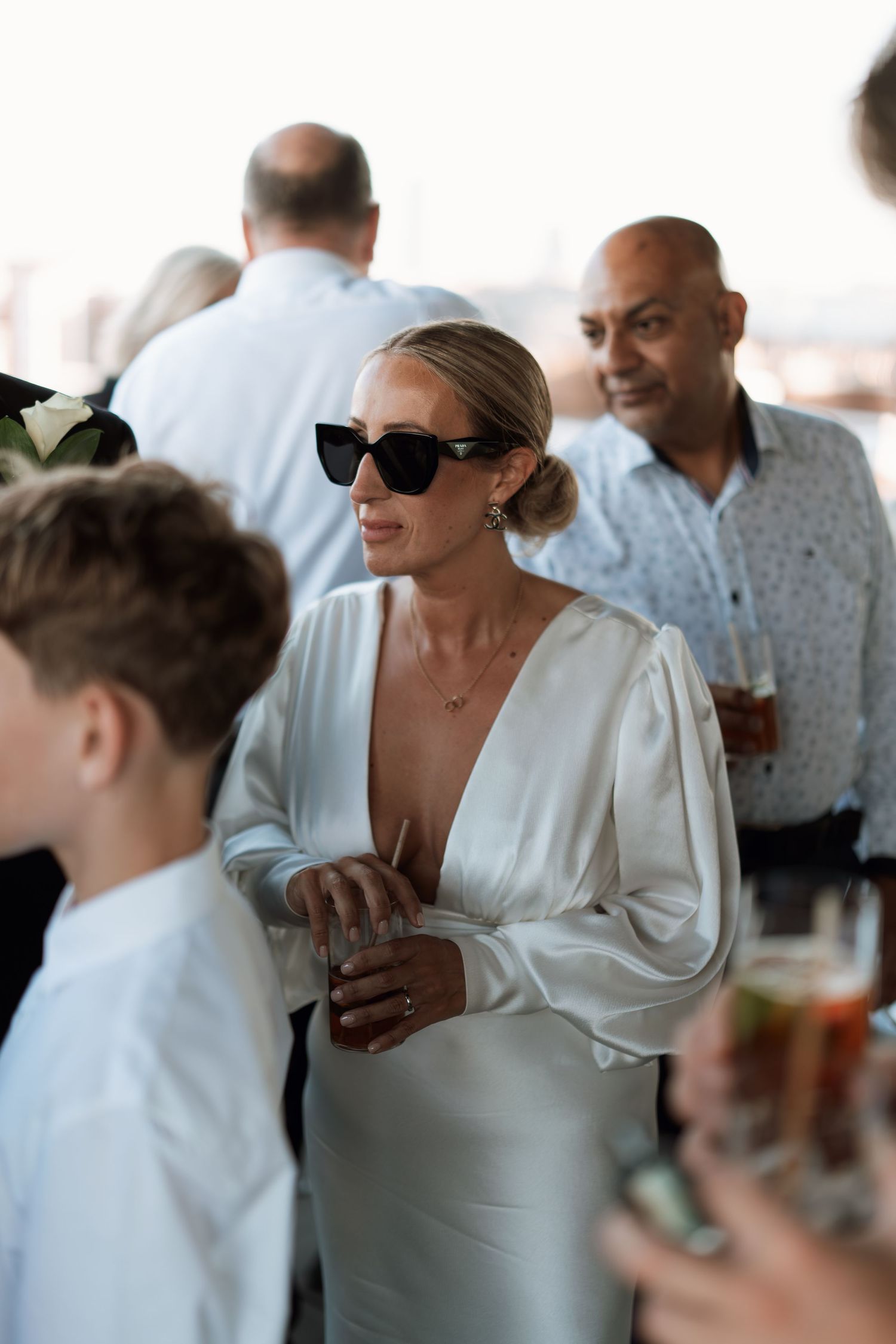 Wedding guests in summer attire mingling at an outdoor reception.