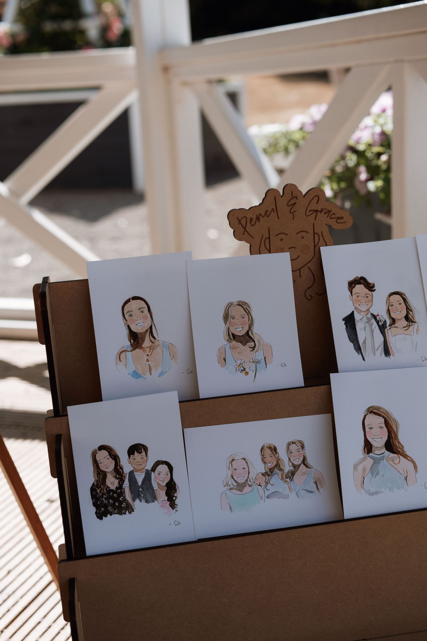 A wooden display board with artistic portrait sketches arranged in a collage style.