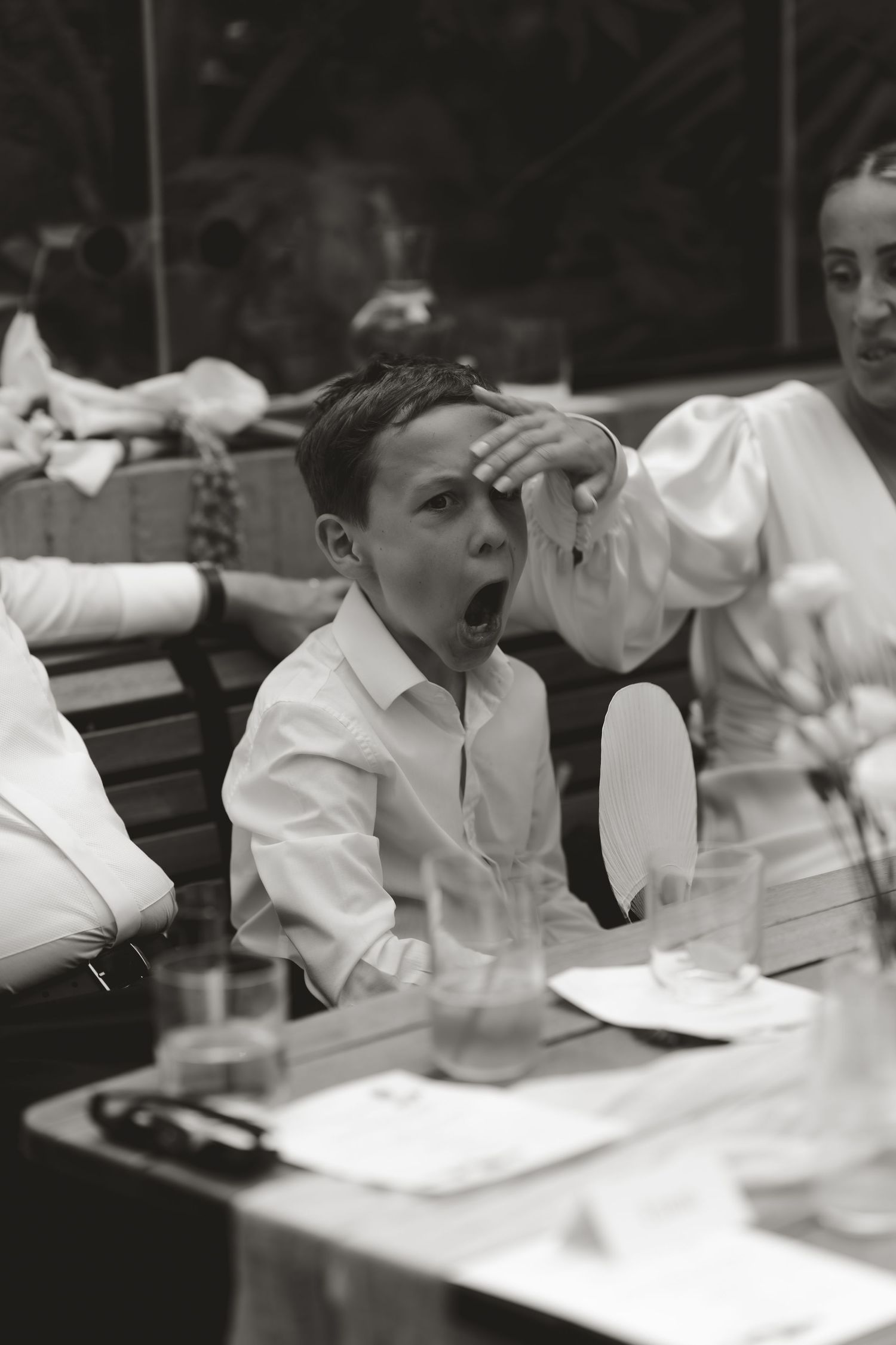 A black and white vintage photo showing expressions of surprise and amusement at what appears to be a dining table.