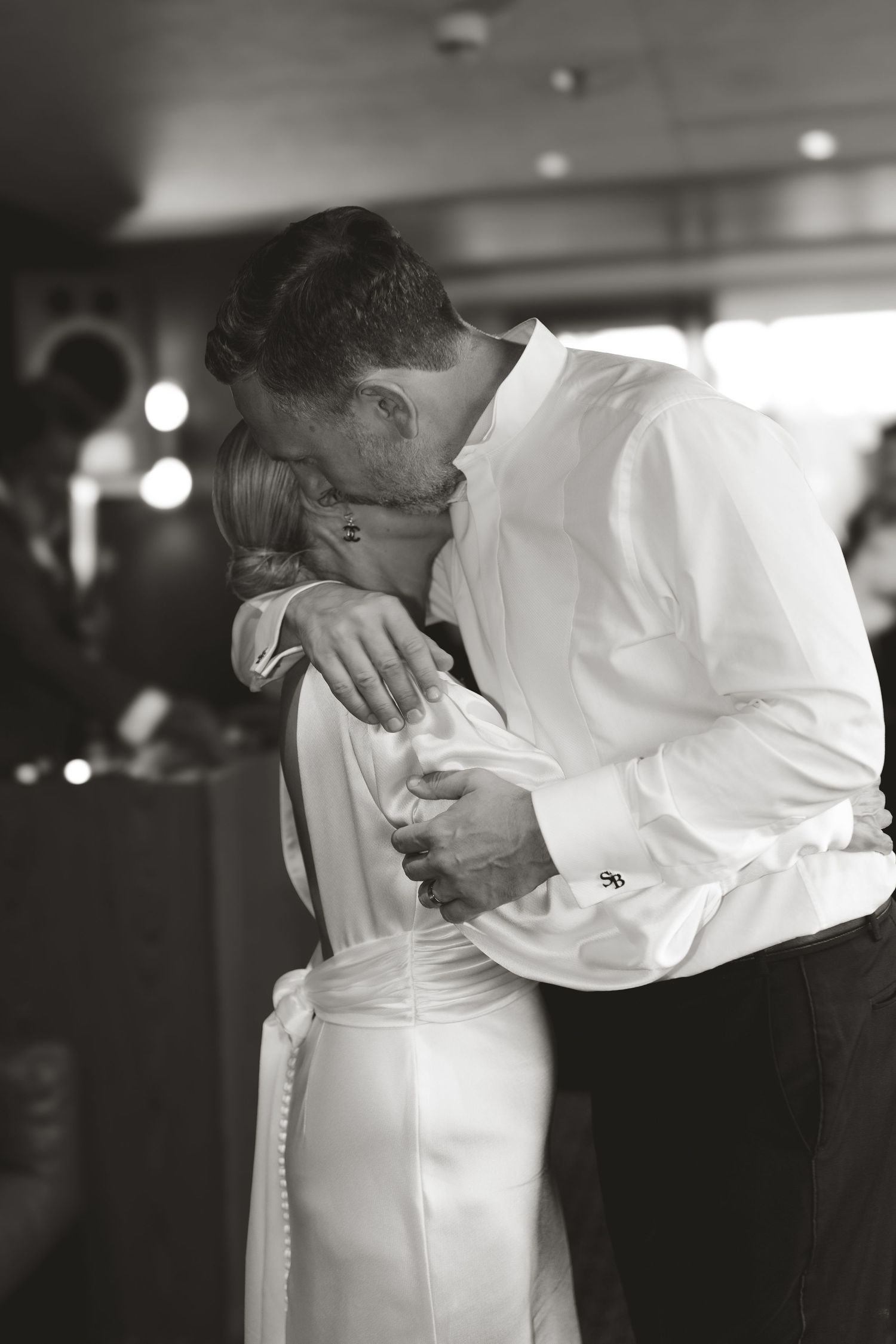 Intimate black and white photo of a couple sharing their first dance at a wedding reception.