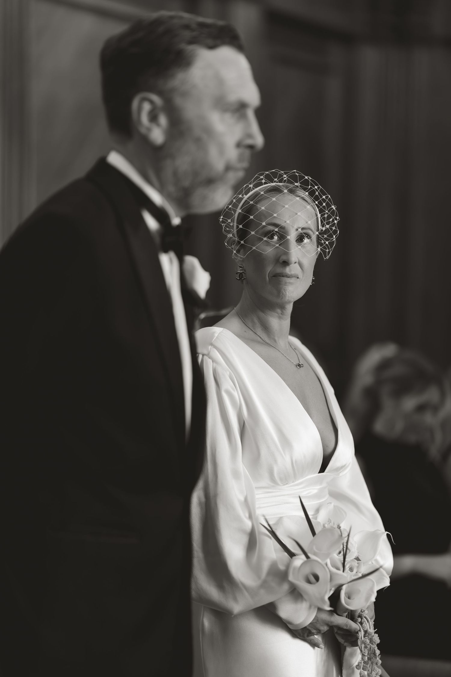 A vintage black and white image shows royal figures in formal attire at a social gathering.