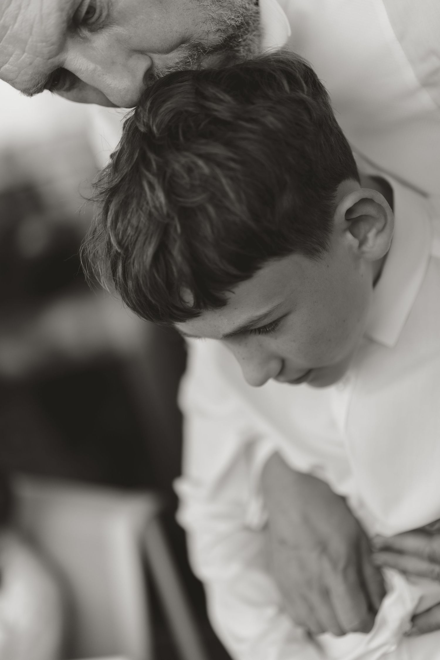 A tender black and white close-up portrait capturing an intimate family moment.