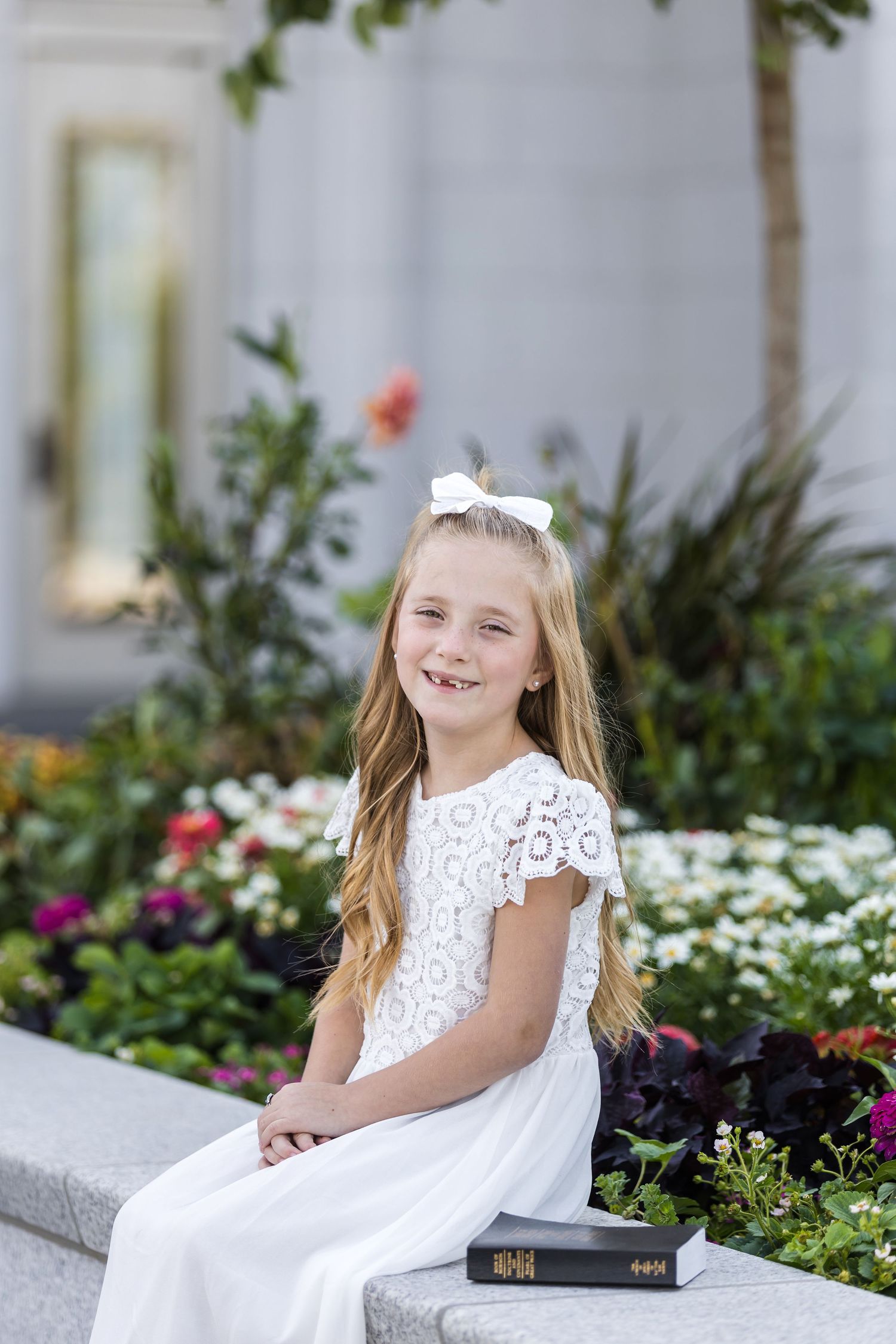 Child holding scriptures and baptism ring during LDS baptism photography session at the Pocatello Idaho LDS Temple.