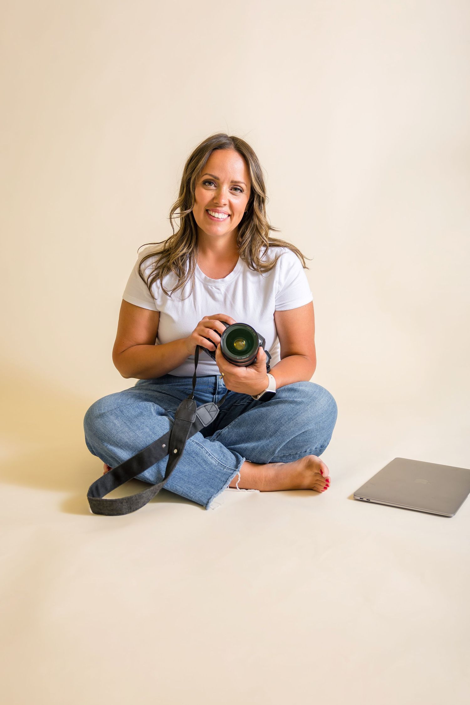Pocatello Idaho photographer. she is sitting with her camera in hand with a smile on her face ready to photograph her clients