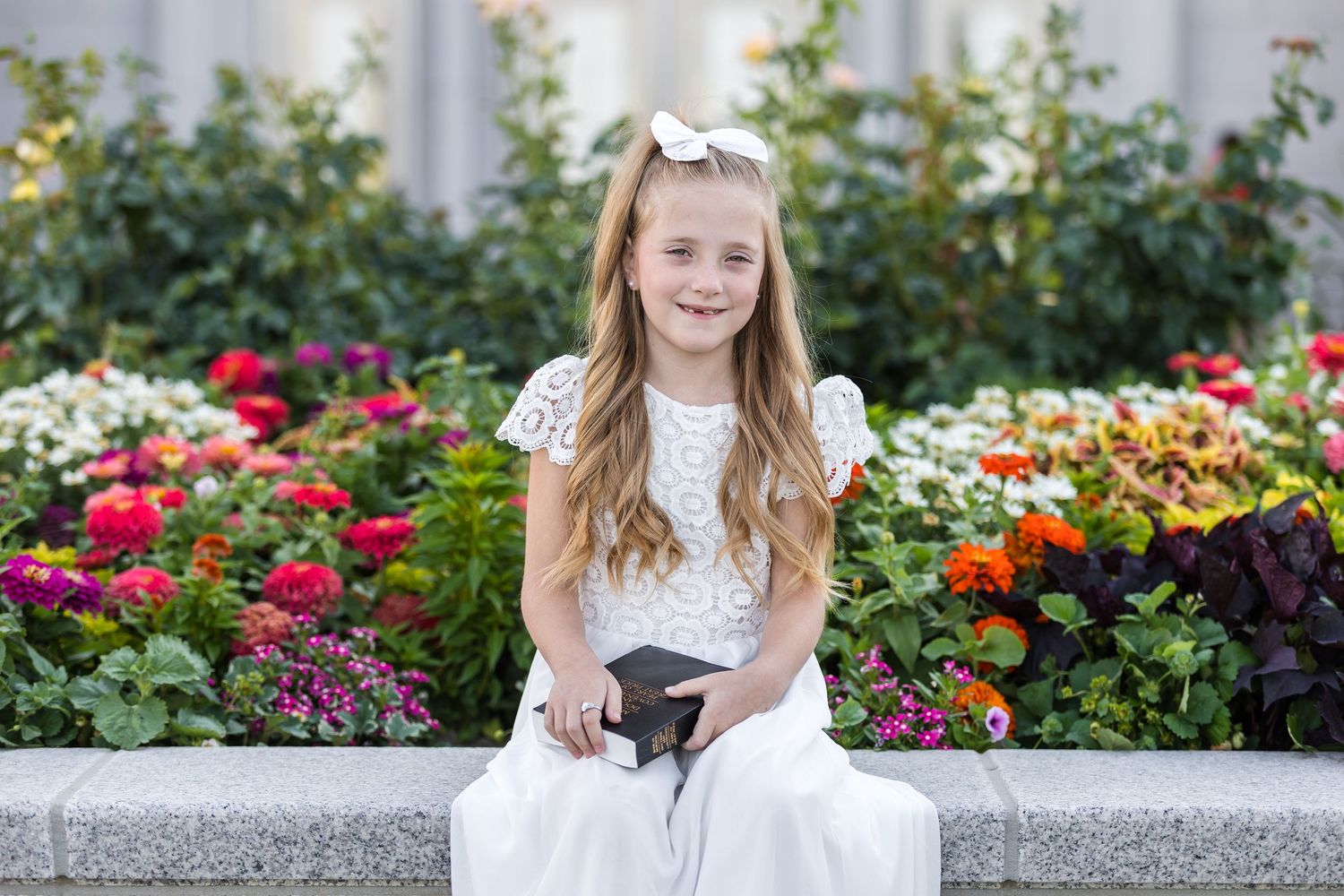 Child holding scriptures and baptism ring during LDS baptism photography session at the Pocatello Idaho LDS Temple.