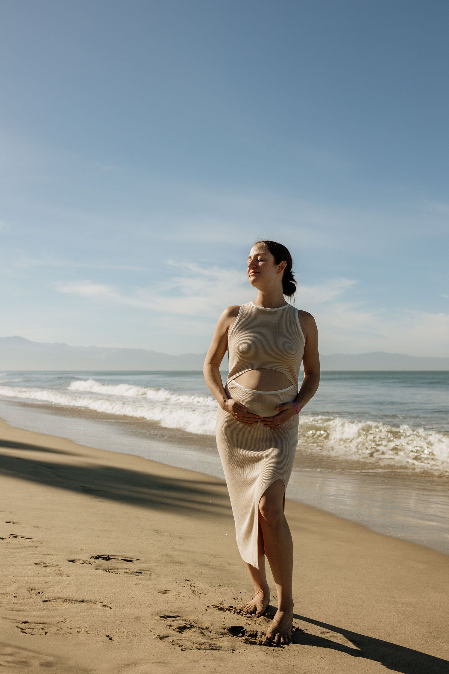 Pregnant woman glowing during sunset maternity session on Sayulita beach