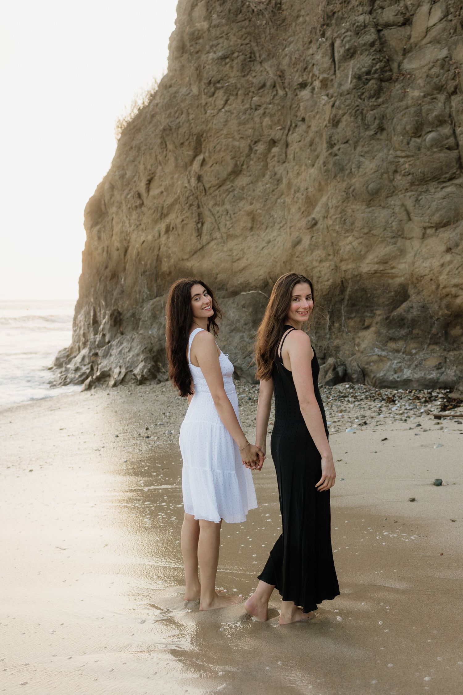 Sisters holding hands during a beach photo shoot in Punta Mita