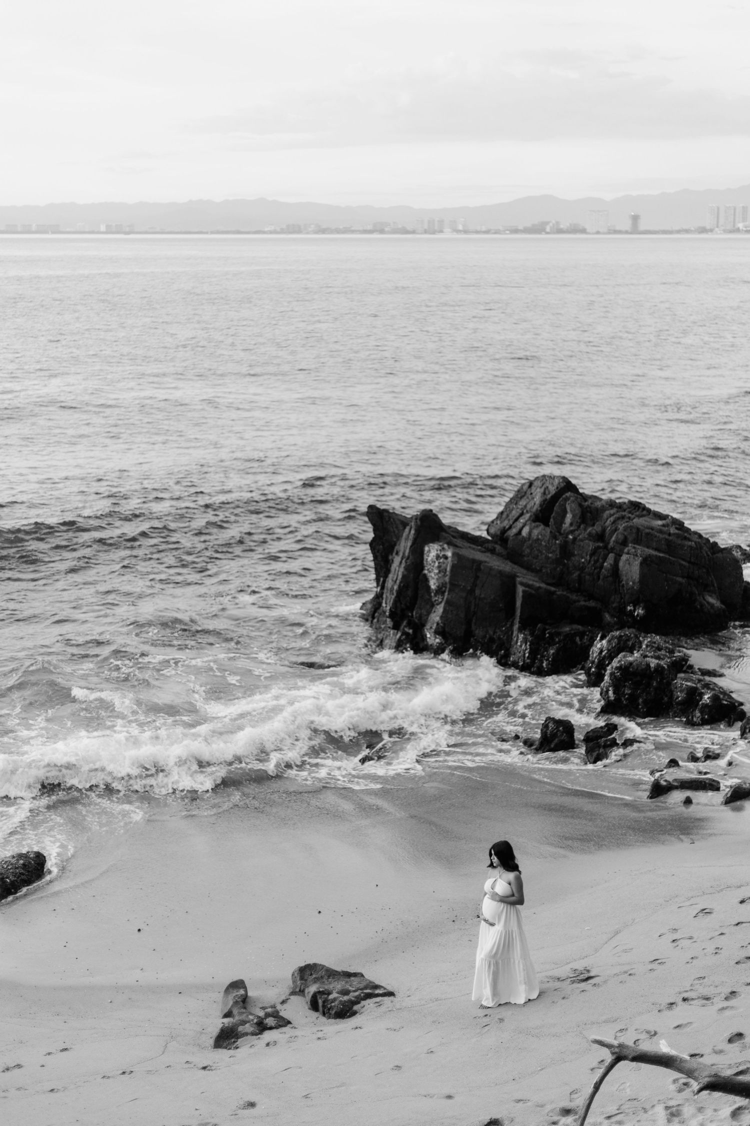 Pregnant woman posing on rocky coastline in Puerto Vallarta
