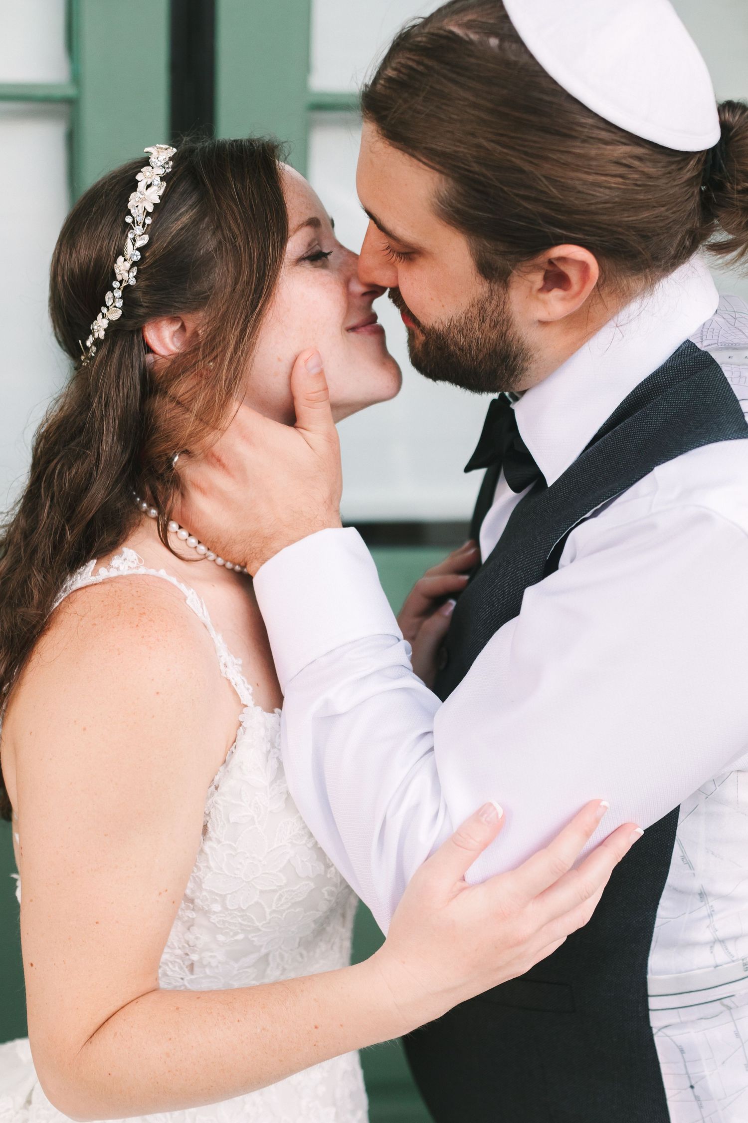 Romantic close-up of bride and groom sharing a tender moment, nearly kissing during their wedding day.