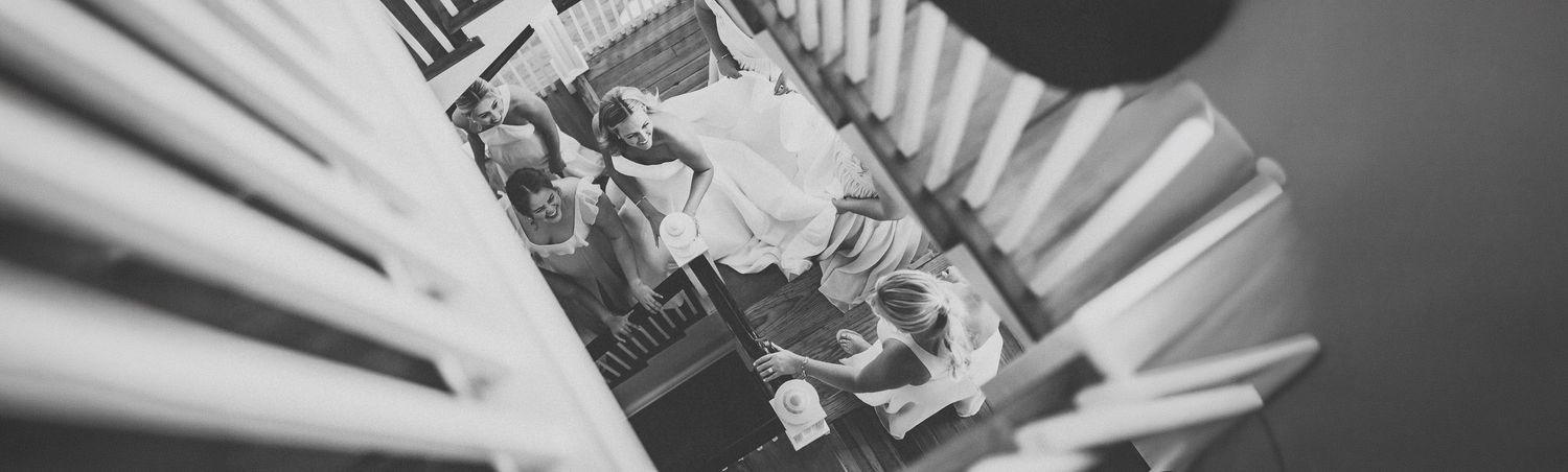 Black and white aerial view of a bride and groom on a staircase, captured from above on their wedding day.
