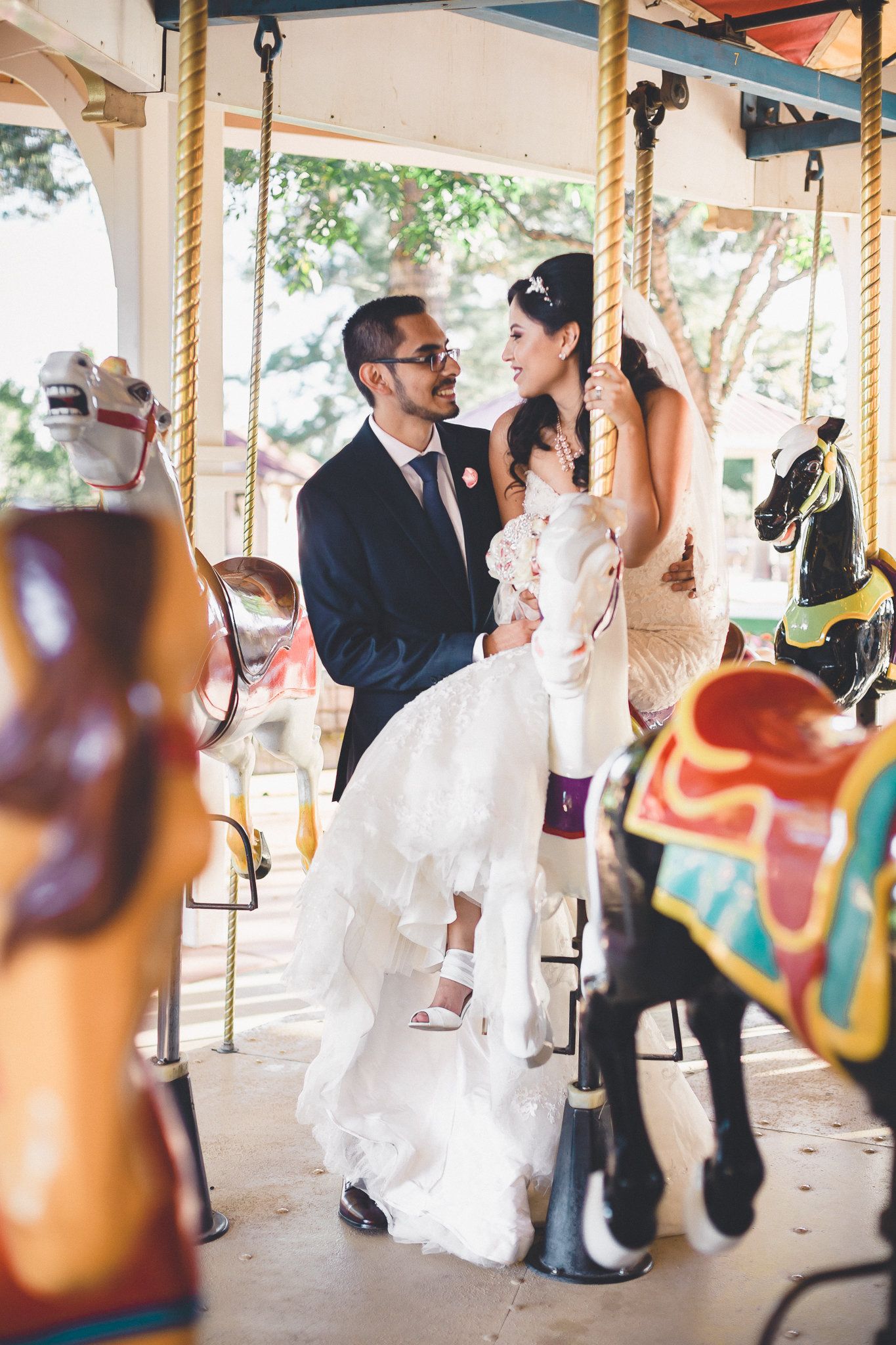 Wedding couple enjoying a colorful carousel on their special day.
