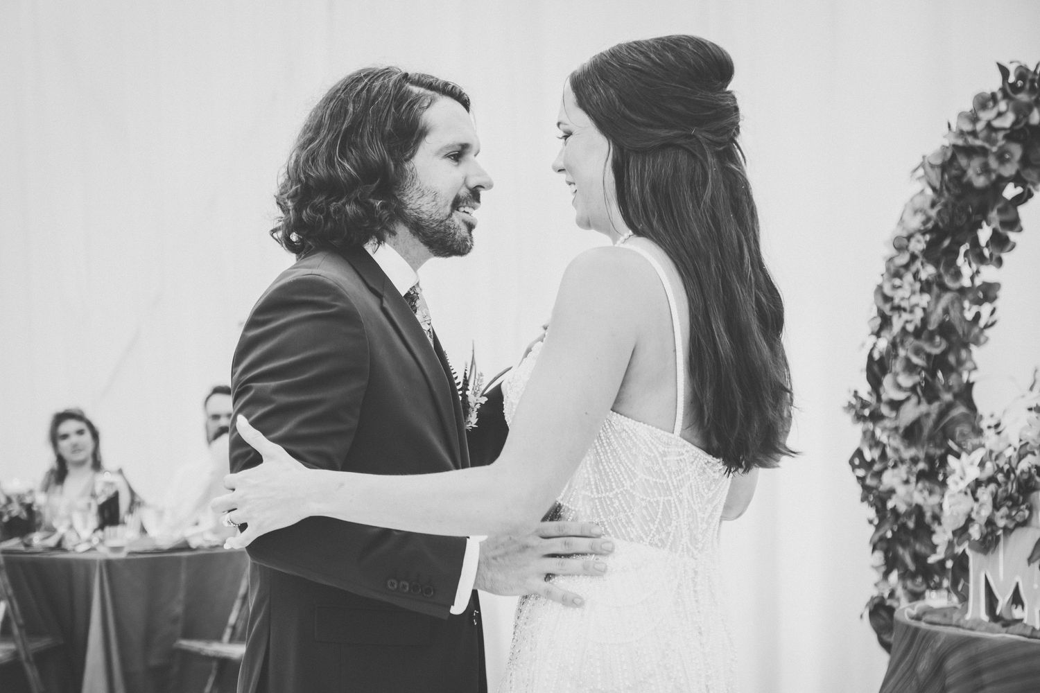Black and white photo of bride and groom sharing first dance at wedding reception.