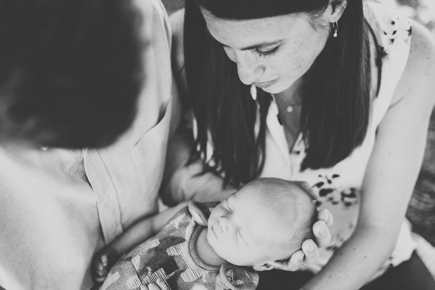 Black and white photo of mother tenderly holding newborn baby.