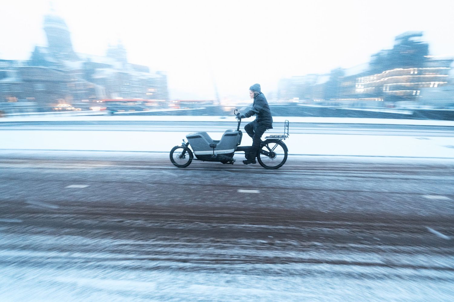 Snowy street photography in Amsterdam capturing the city covered in snow with soft light and a quiet winter atmosphere.