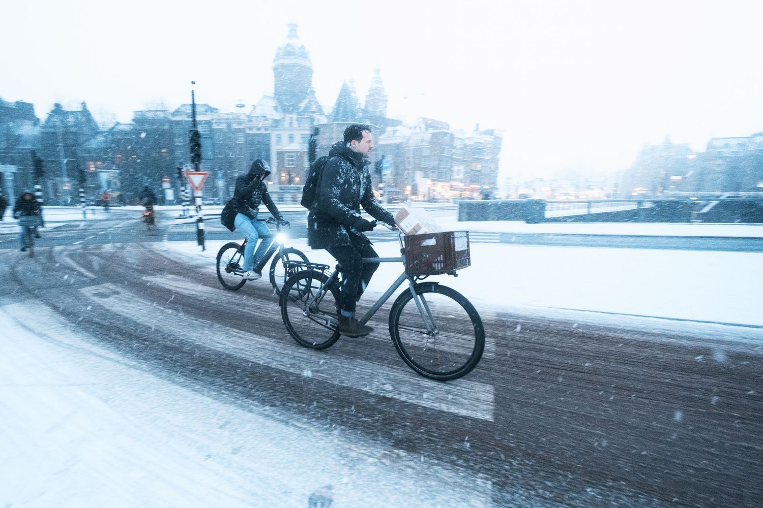 Snowy street photography in Amsterdam capturing the city covered in snow with soft light and a quiet winter atmosphere.