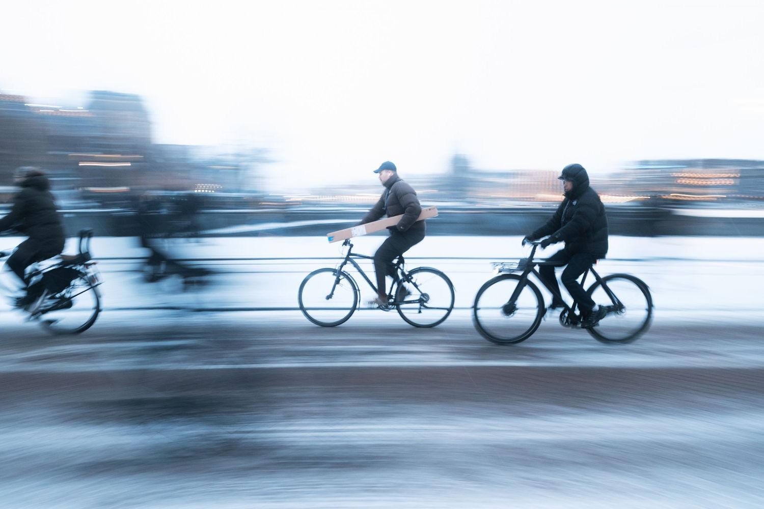 Snowy street photography in Amsterdam capturing the city covered in snow with soft light and a quiet winter atmosphere.