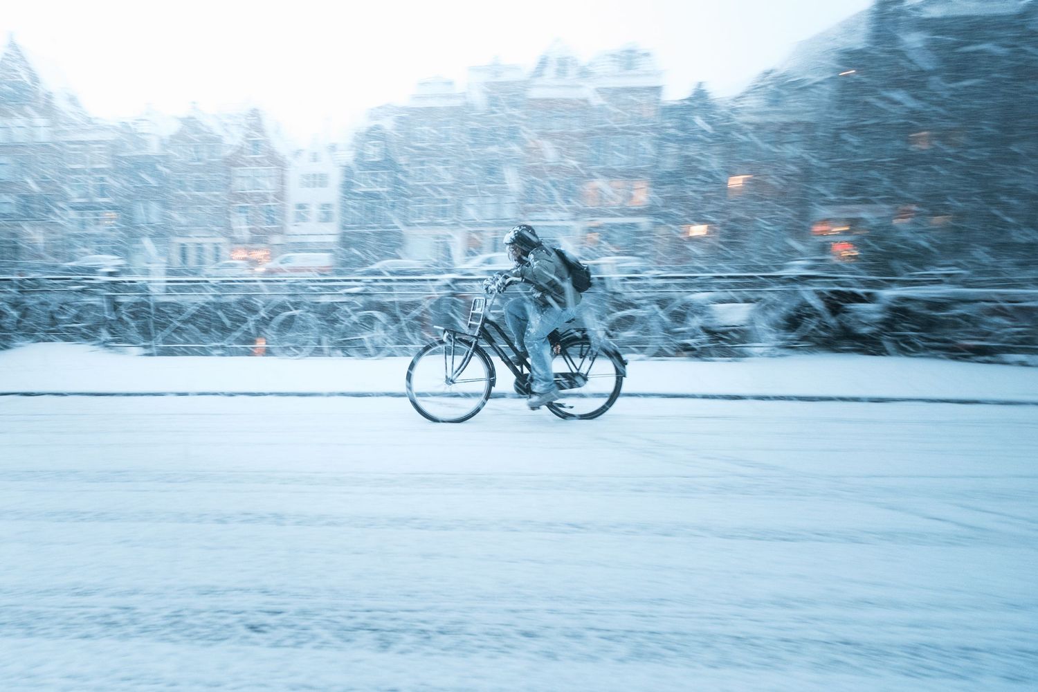 Snowy street photography in Amsterdam capturing the city covered in snow with soft light and a quiet winter atmosphere.