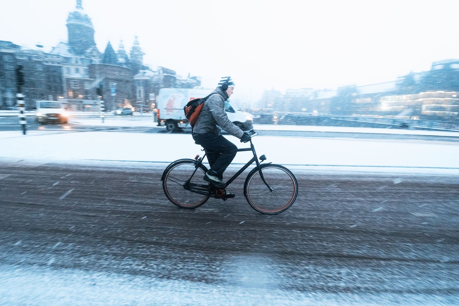 Snowy street photography in Amsterdam capturing the city covered in snow with soft light and a quiet winter atmosphere.