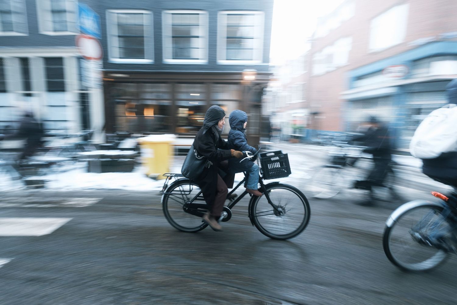 Snowy street photography in Amsterdam capturing the city covered in snow with soft light and a quiet winter atmosphere.