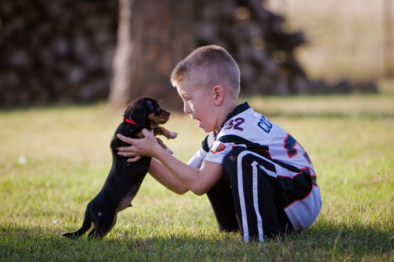 Boy and his new puppy in Oklahoma Cowboy's jersey