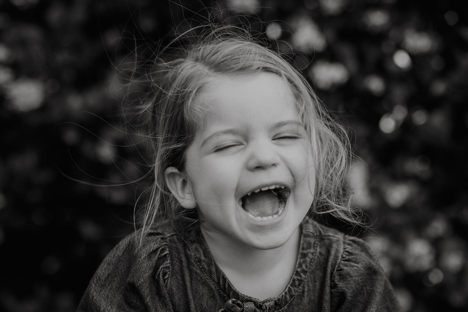 Black and white portraits showing various expressions of happiness and laughter.