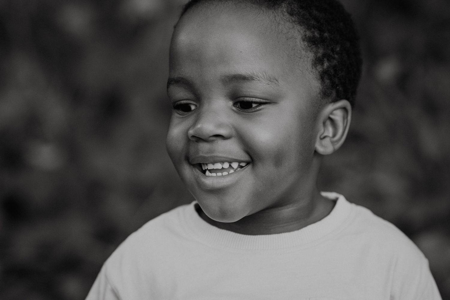 Black and white portrait of child with gentle expression.