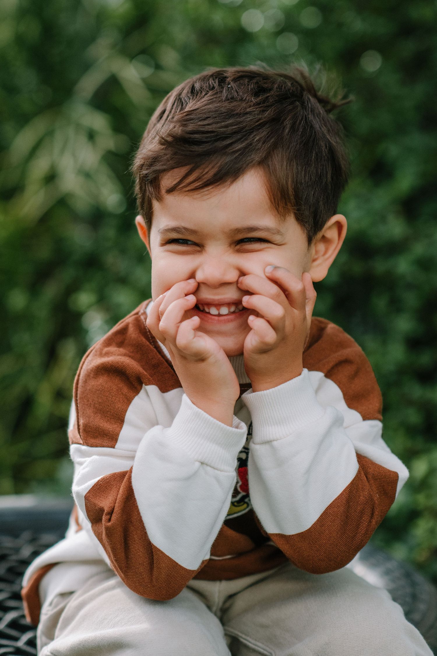 Playful sequence showing giggles and covered smiles in brown and white clothing.