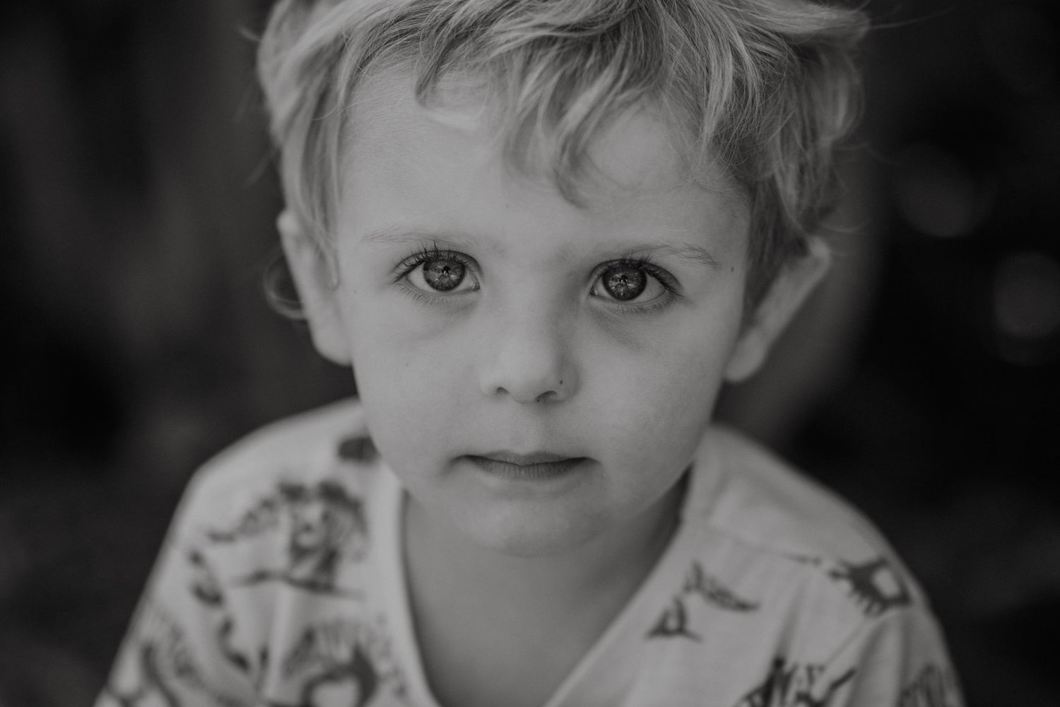 Black and white artistic portrait of a child with expressive eyes.