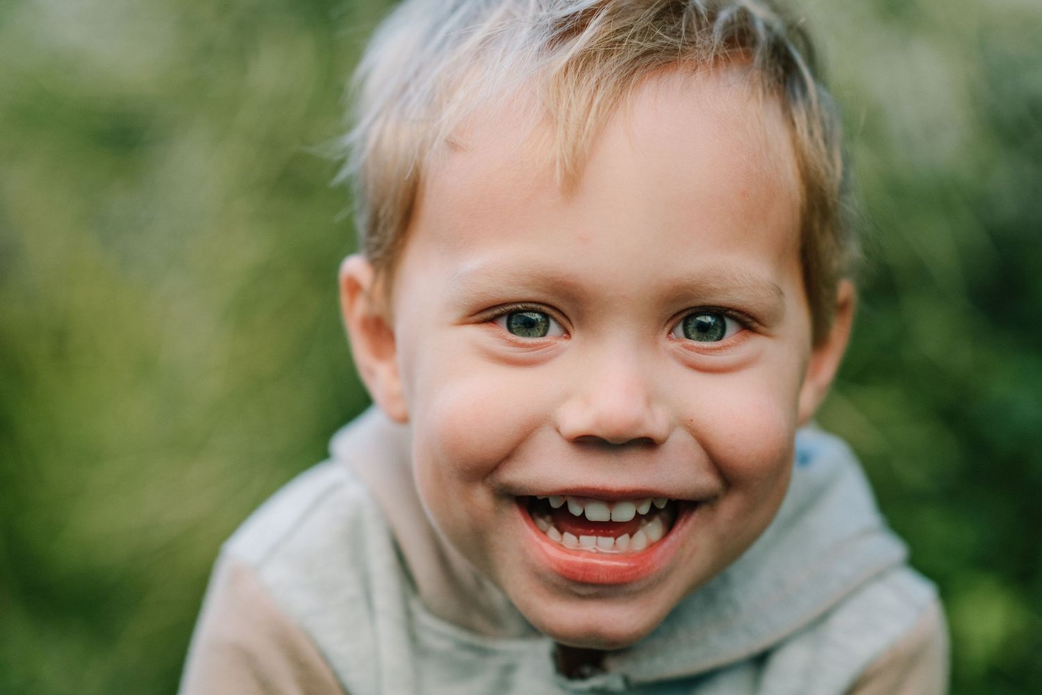 Close up portraits of children showing various playful expressions outdoors.