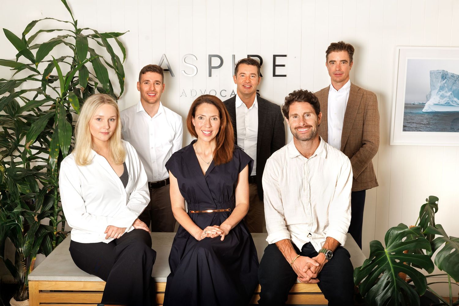 Professional team portrait in a modern office setting, showcasing confident business people in a clean, natural workspace.