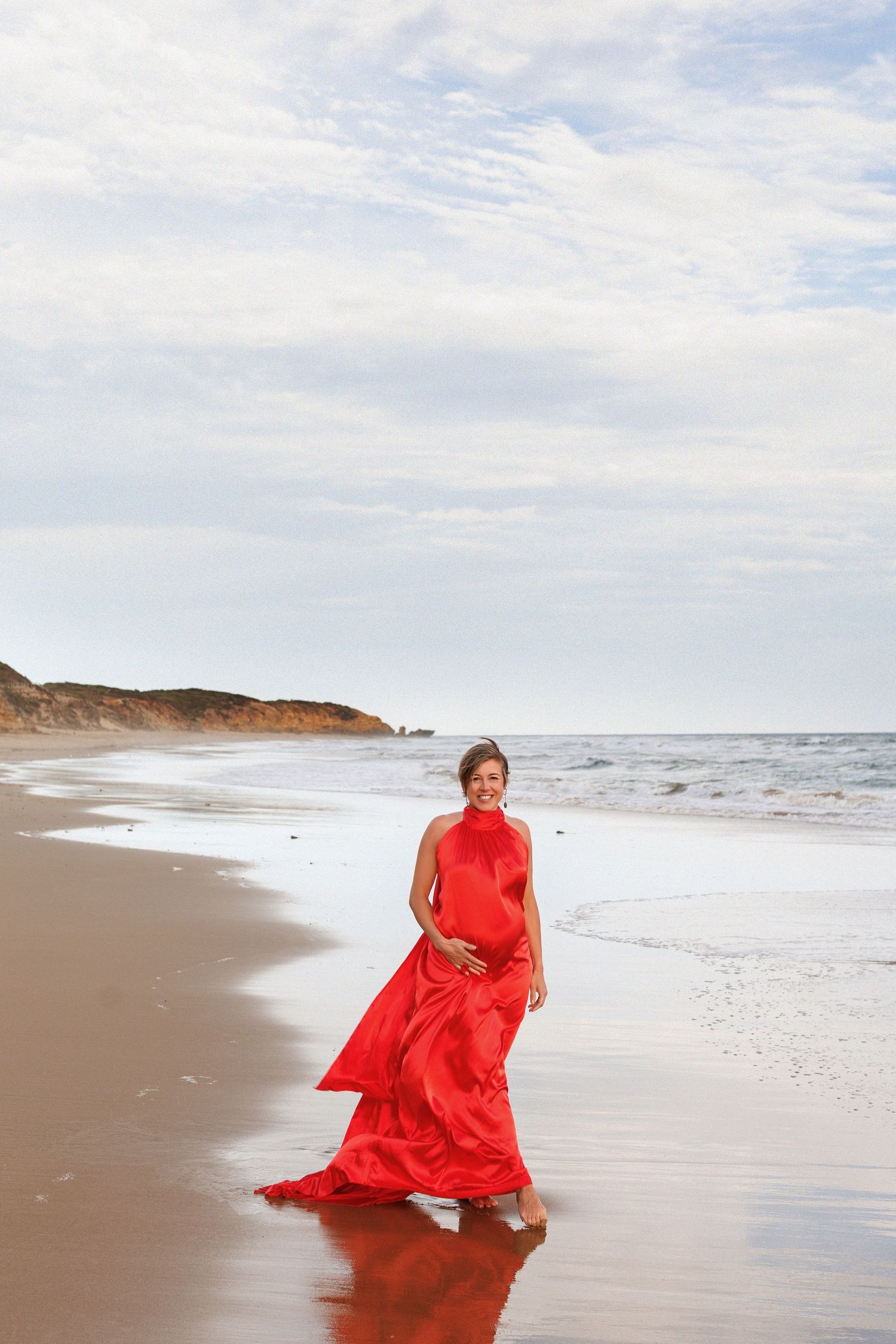 Elegant maternity photography on the beach with flowing dress