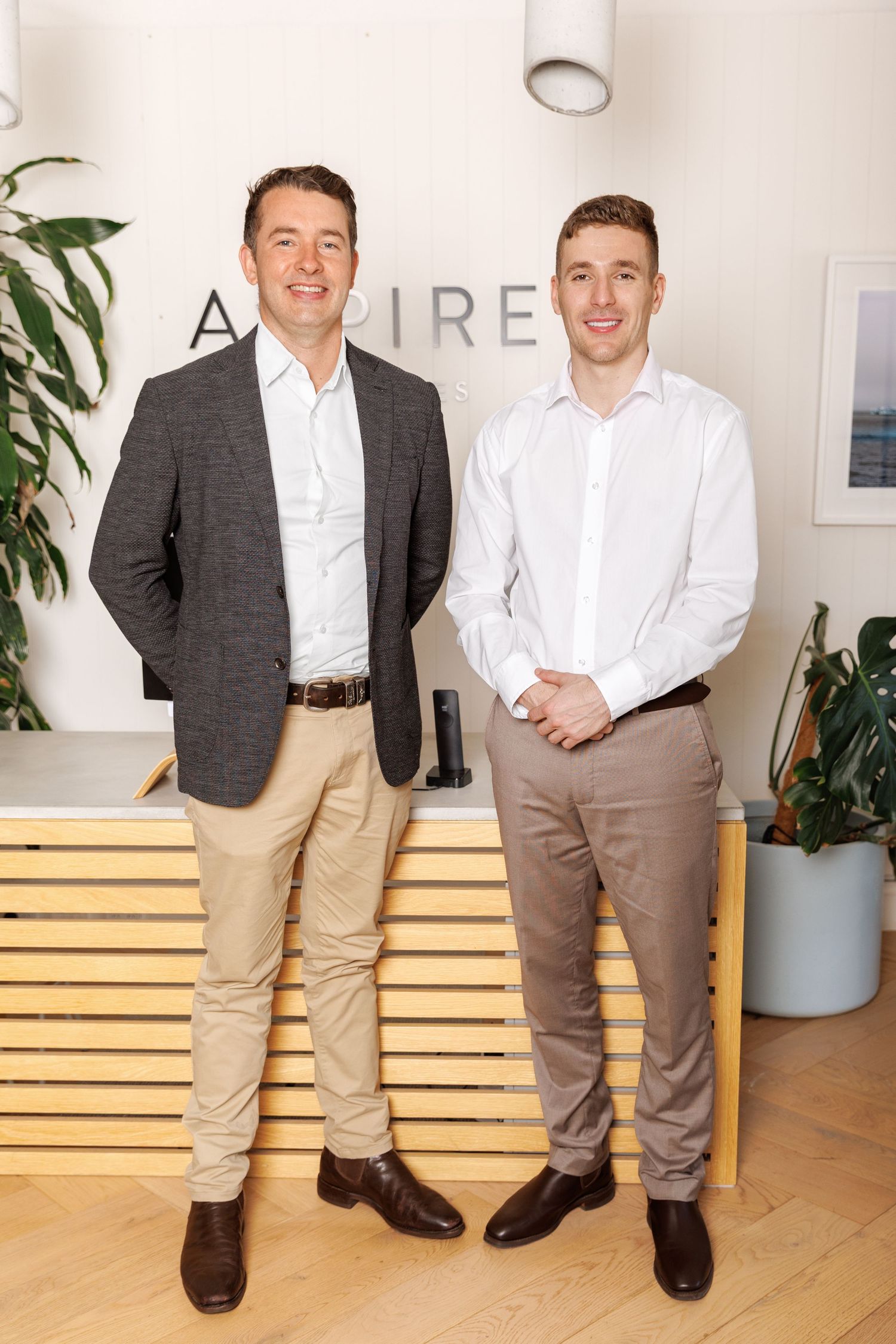Professional team portrait in a modern office setting, showcasing confident business people in a clean, natural workspace.