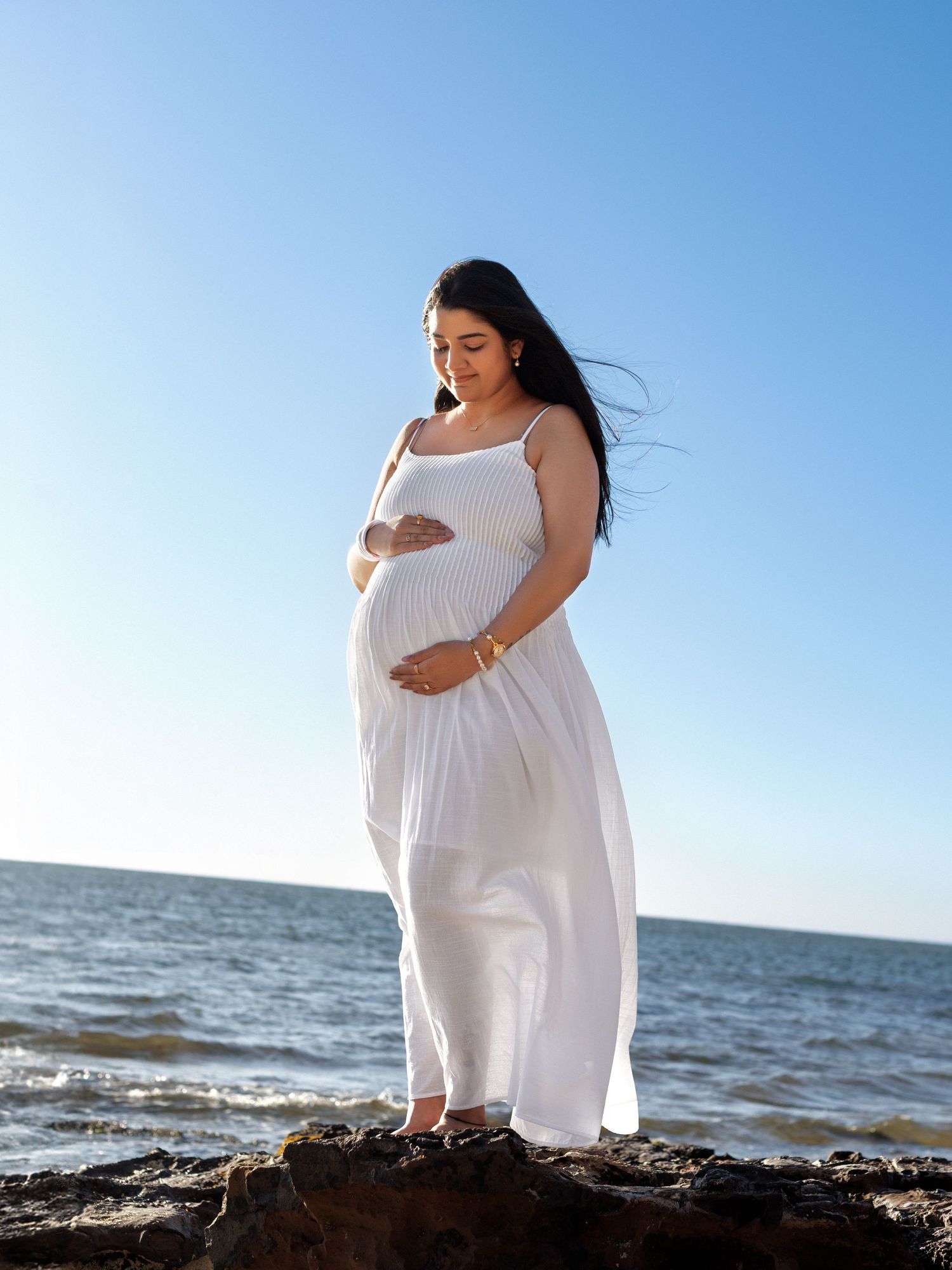Pregnancy photography session by the sea at golden hour