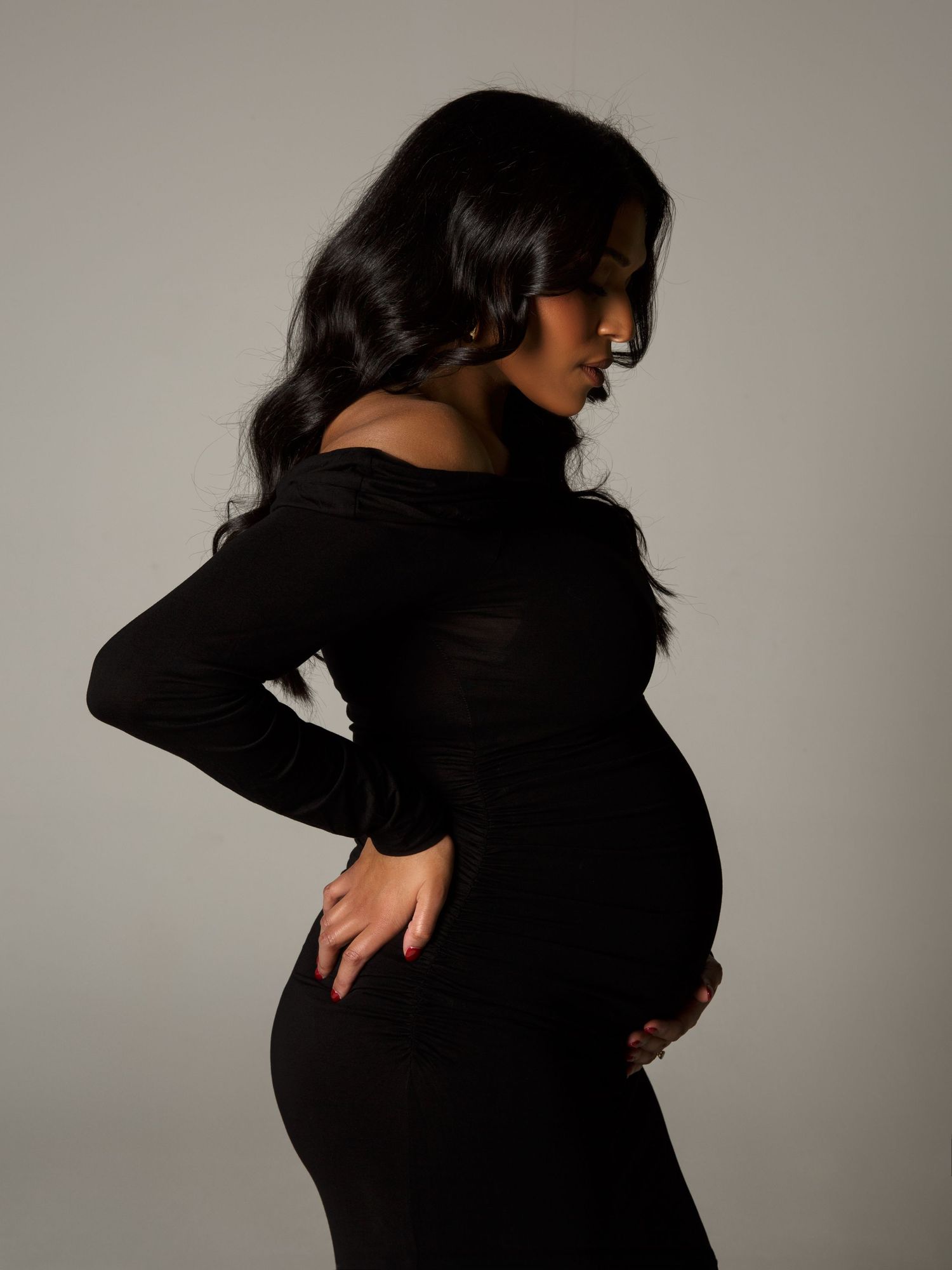 Maternity photoshoot in studio highlighting form with studio lighting