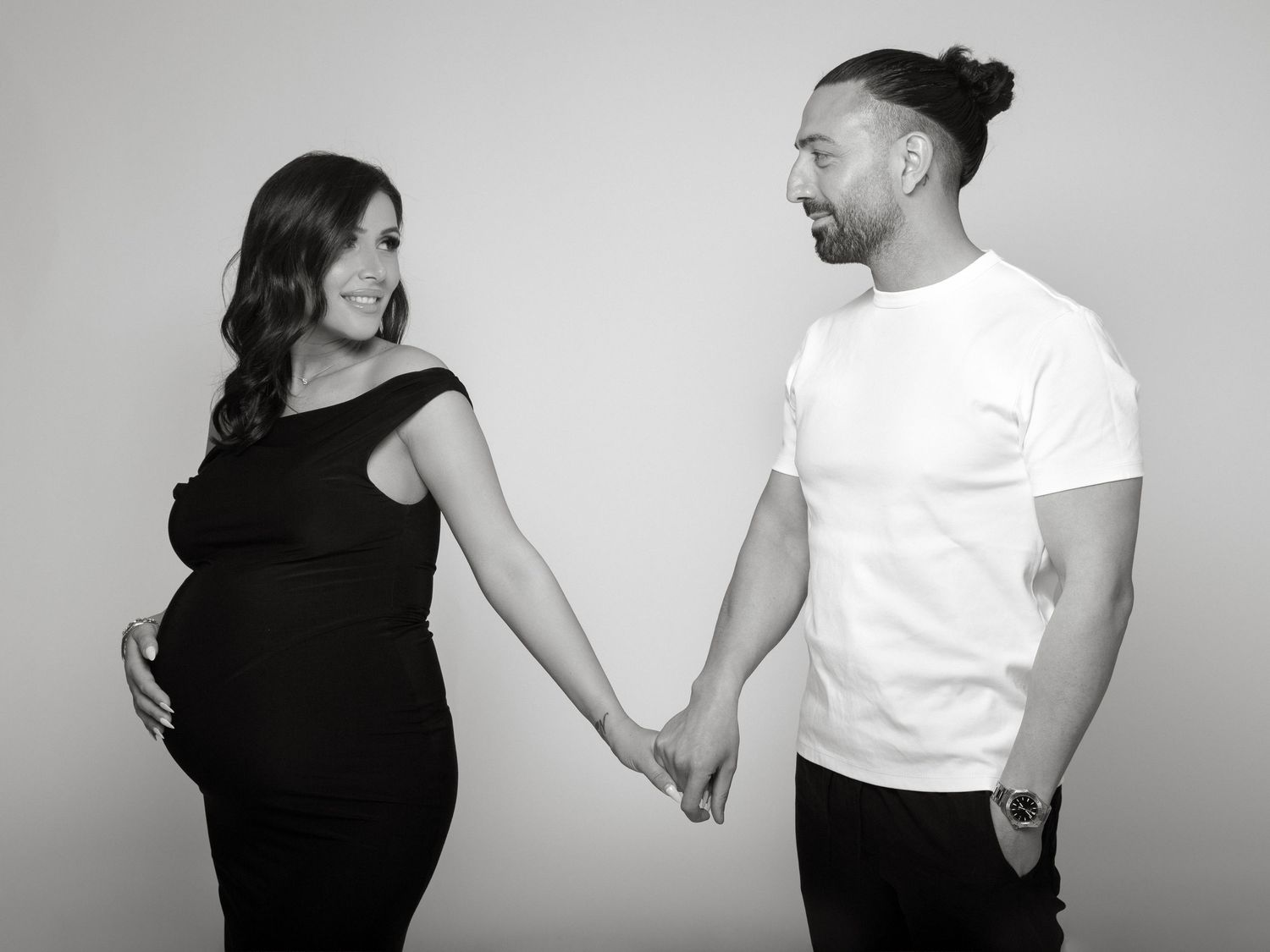 Maternity photoshoot in studio featuring a flowing maternity dress