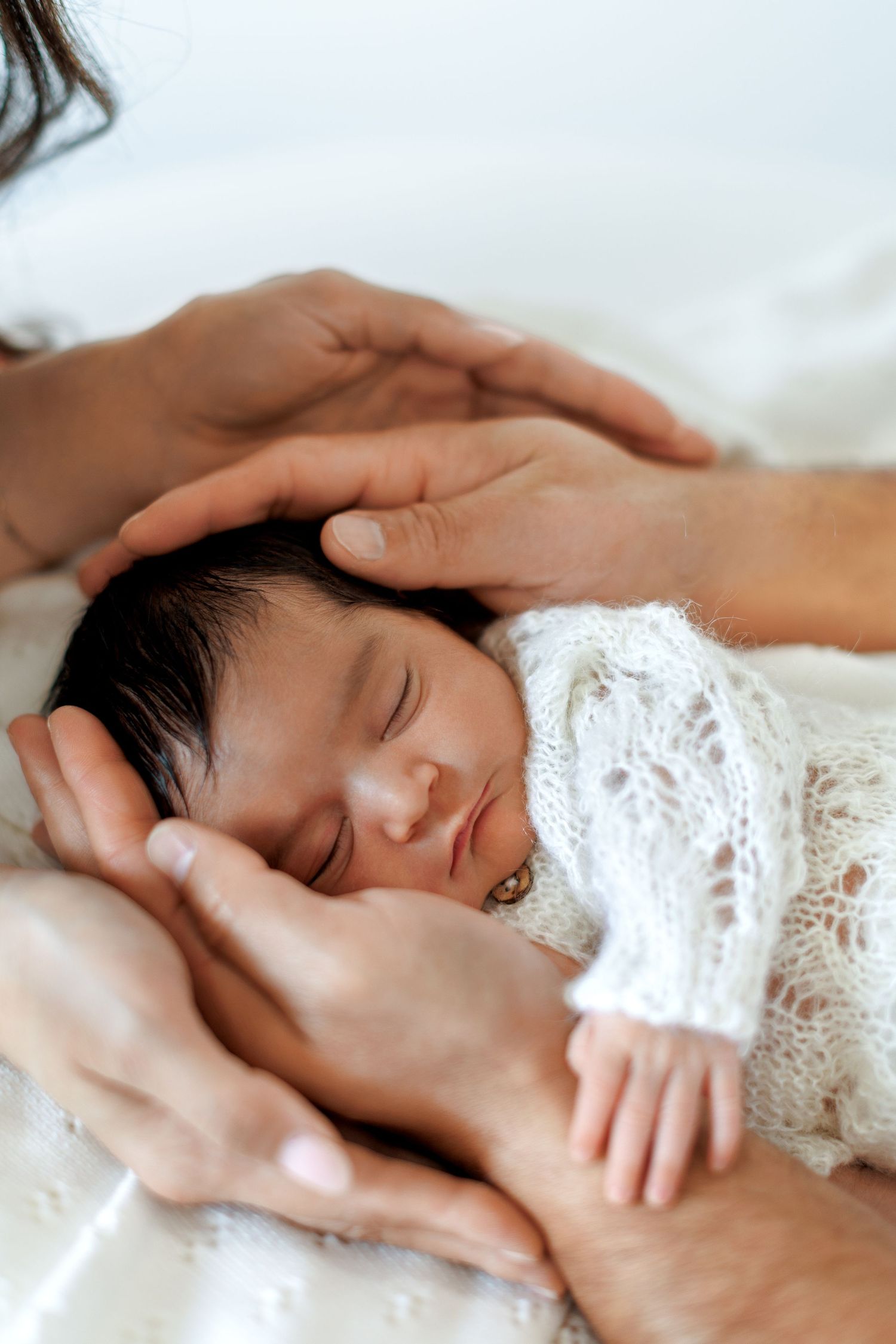 Newborn photography portrait with soft fabrics and neutral styling