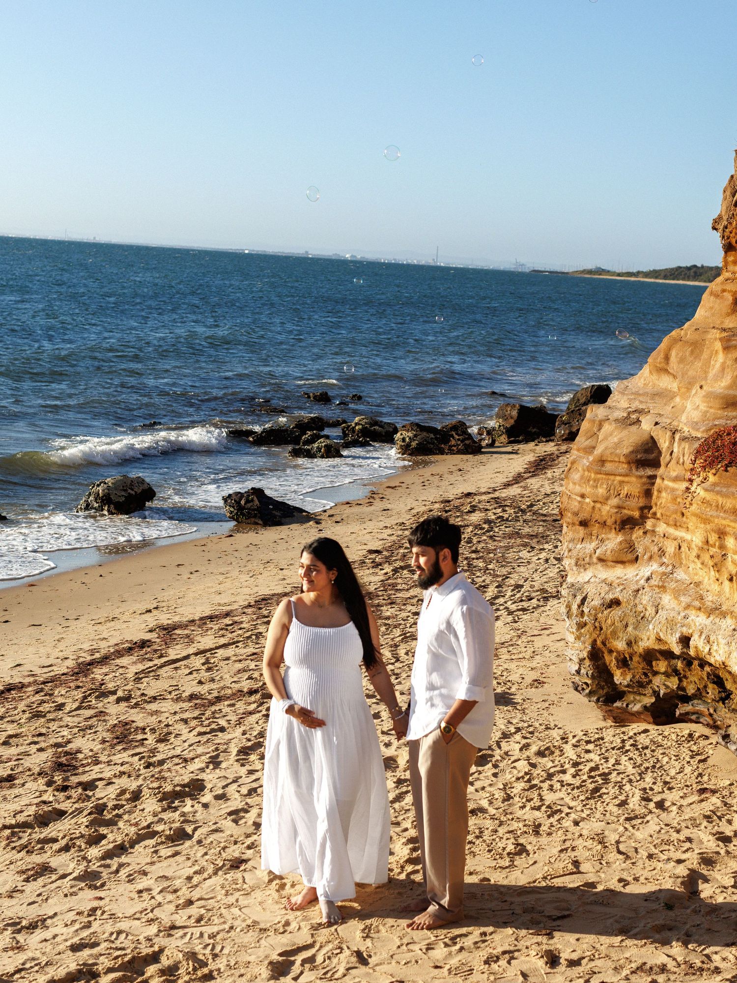 Outdoor maternity photoshoot on the beach with ocean background