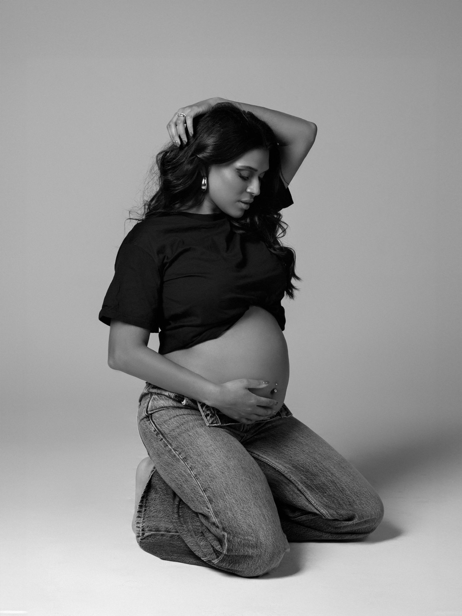 Studio maternity photoshoot with gentle lighting and clean background