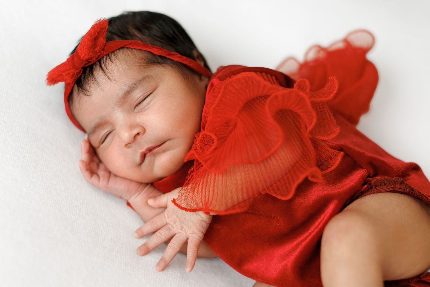 Newborn photography portrait of a baby wrapped in soft neutral tones