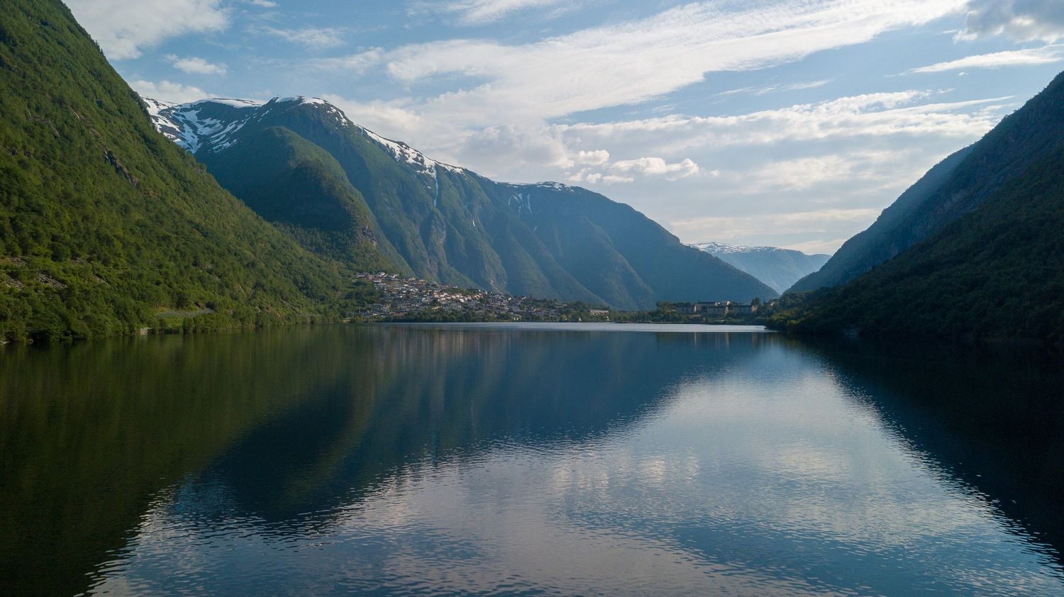 Reflective scene of mountains over an ocean in Norway