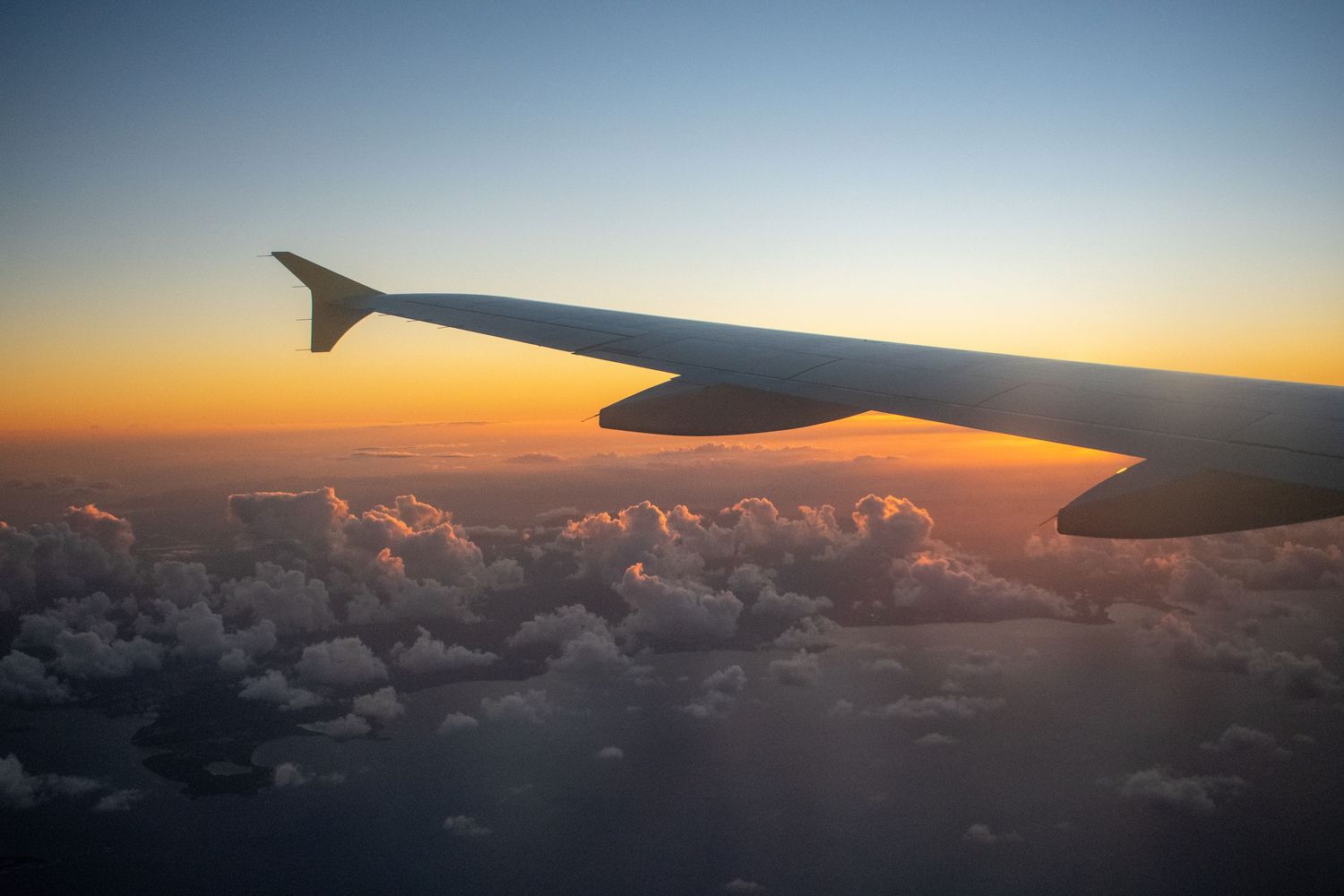airplane wing at sunset during a flight