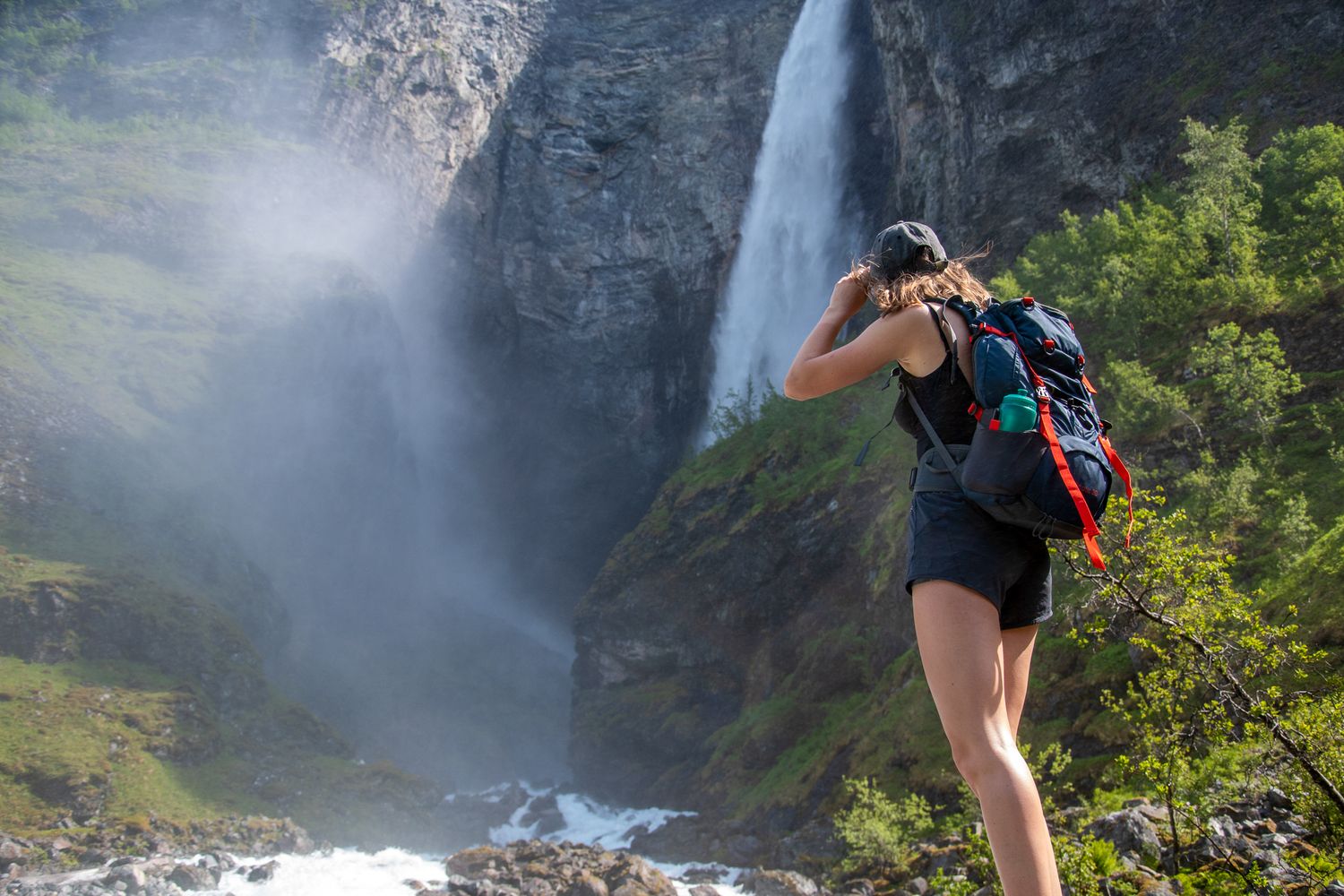 hiker looking at waterfall in norway