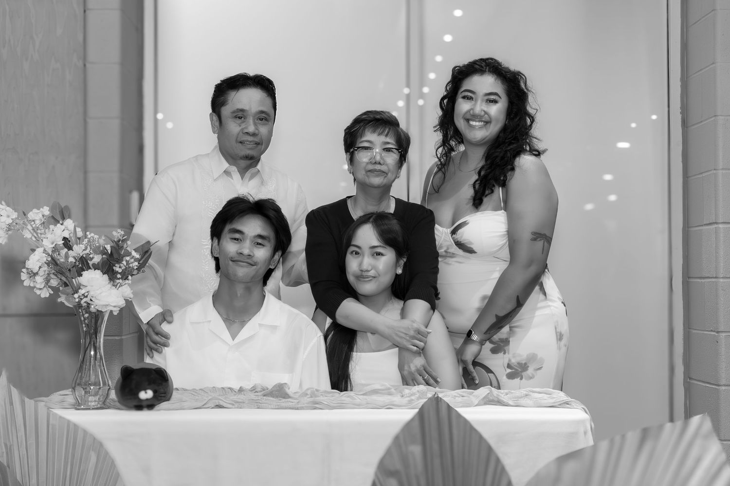 Black and white family portrait of five people posing together at a formal event, smiling at the camera.