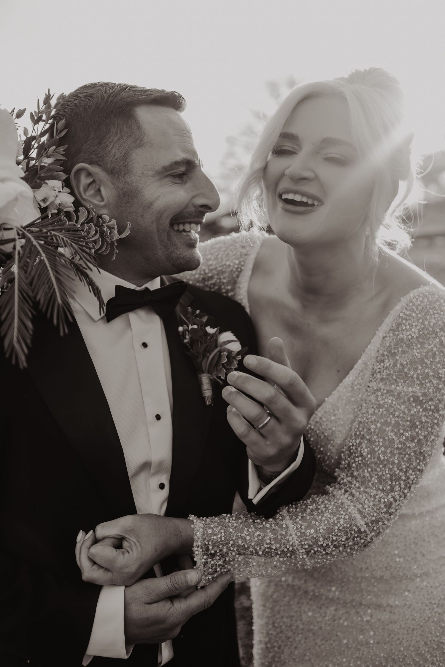 A joyful wedding couple shares a playful moment while eating chocolate chip cookies in a black and white photo series.